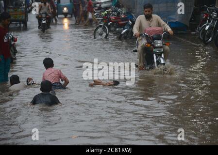 Lahore, Pakistan. 20 luglio 2020. I pendolari pakistani si muovono attraverso una strada allagata dopo il pesante incantesimo pioggia monsone nella capitale provinciale di Lahore. (Foto di Rana Sajid Hussain/Pacific Press) Credit: Pacific Press Agency/Alamy Live News Foto Stock