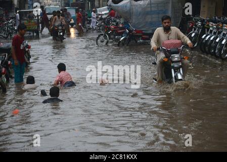 Lahore, Pakistan. 20 luglio 2020. I pendolari pakistani si muovono attraverso una strada allagata dopo il pesante incantesimo pioggia monsone nella capitale provinciale di Lahore. (Foto di Rana Sajid Hussain/Pacific Press) Credit: Pacific Press Agency/Alamy Live News Foto Stock