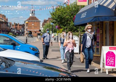 Old Amersham nel Buckinghamshire, Inghilterra, Regno Unito. 20 luglio 2020. I negozi e le aziende del centro città in Inghilterra si sono riaperti a seguito dell'allentamento delle restrizioni di blocco pandemiche del coronavirus. Una famiglia cammina lungo la strada alta indossando maschere mentre fuori shopping. I rivestimenti per il viso saranno un requisito legale quando si visitano i negozi da venerdì 24 luglio 2020. Foto Stock