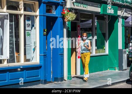 Clonakilty, West Cork, Irlanda. 20 luglio 2020. Oggi è stato il primo giorno di maschera obbligatoria indossando in negozi e negozi, a causa dell'aumento dei casi di Covid-19. Molti acquirenti a Clonakilty indossavano maschere, e altrettanto molti non lo facevano. Credit: Notizie dal vivo di AG/Alamy Foto Stock