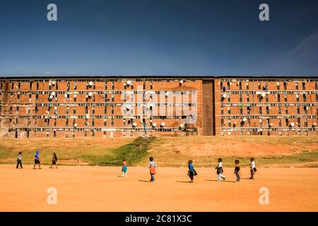 Bambini che giocano fuori di un ostello lavoratori in Alexandra Township; Johannesburg, Gauteng, Sudafrica Foto Stock