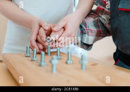 Primo piano dell'uomo in terapia professionale avvitamento del dado sul bullone Foto Stock