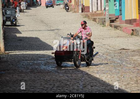 Trinidad, Cuba, 16.12.2018 Moto con sidecar e passeggero in strada Foto Stock