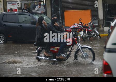 Lahore, Pakistan. 20 luglio 2020. I pendolari pakistani si sono guastati attraverso una strada allagata dopo un pesante incantesimo di pioggia monsone nella capitale provinciale di Lahore, Pakistan, il 20 luglio 2020. (Foto di Rana Sajid Hussain/Pacific Press/Sipa USA) Credit: Sipa USA/Alamy Live News Foto Stock