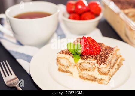 Tiramisù - Dessert classico guarnito con fragola e menta Foto Stock