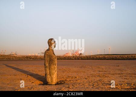 Statua di Iron Man fino alle sue cosce in sabbia vista sulla spiaggia di Crosby vicino Liverpool (Inghilterra) nel luglio 2020. Foto Stock