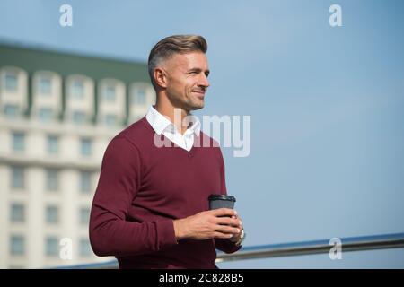 Armonia e equilibrio energetico della vita. Cura di sé. Momenti piacevoli. Tranquillità. Pausa caffè. Bere caffè in movimento. Rilassati e ricaricati. Bel ragazzo tenere caffè tazza cielo sfondo spazio copia. Foto Stock