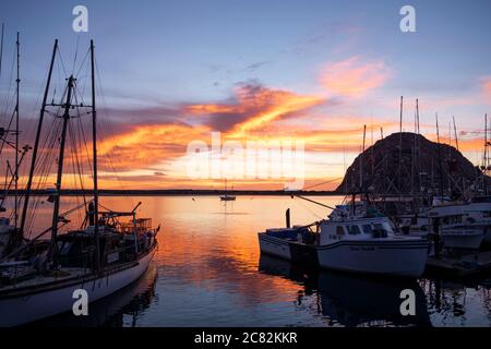 Tramonto fiery riflesso nella baia di Morro tra le barche da pesca in una serata tranquilla Foto Stock