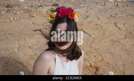 giovane donna che guarda la macchina fotografica con una tiara di fiori Foto Stock