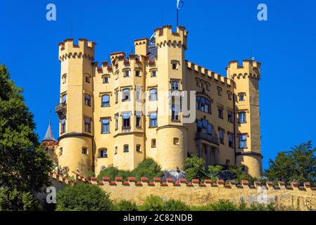Castello di Hohenschwangau vicino a Fussen, Germania. Questo castello è una famosa attrazione turistica delle Alpi bavaresi. Vista panoramica del castello tedesco contro il cielo in somma Foto Stock