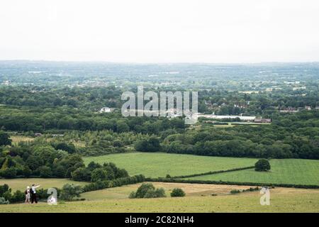 Persone che si levano in piedi e puntano attraverso il paesaggio del Weald Sussex, Clayton, Regno Unito Foto Stock