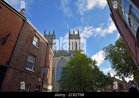 Guardando verso le torri occidentali di York Minster da High Petergate. Gli edifici in mattoni rossi sono in primo piano. Yorkshire Inghilterra. Foto Stock