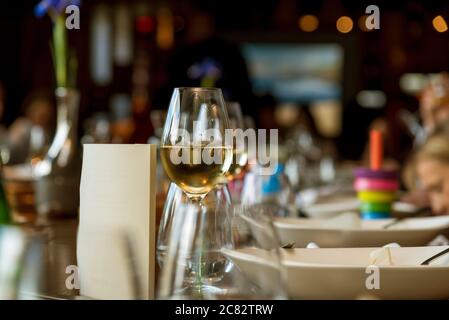 Un partito con una deliziosa cena e un bicchiere di vino bianco Foto Stock