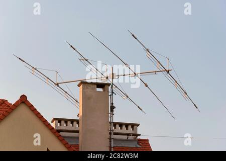 Antenna TV sul tetto della casa. Tecnologia di trasmissione televisiva e radio sul tetto. Ricevitore del segnale. Torre dei supporti di trasmissione. Copertura residenziale wit Foto Stock