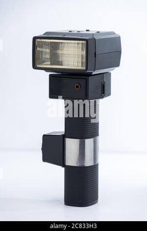 La fotocamera Speedlight nera lampeggia su sfondo bianco Foto Stock