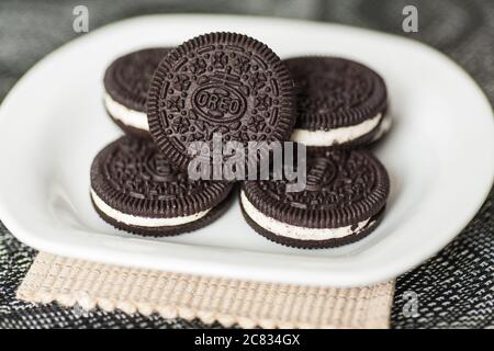 I biscotti Oreo vengono riponati su un piatto bianco Foto Stock