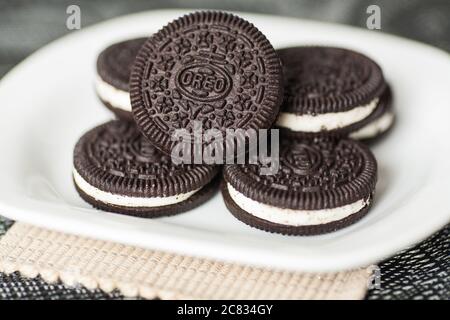 I biscotti Oreo vengono riponati su un piatto bianco Foto Stock