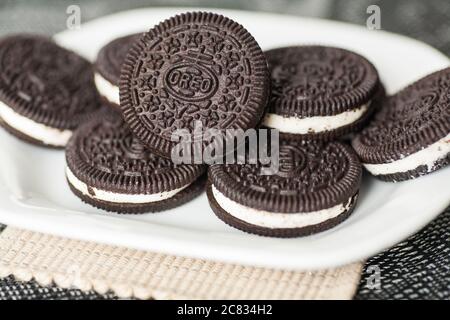 I biscotti Oreo vengono riponati su un piatto bianco Foto Stock