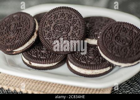 I biscotti Oreo vengono riponati su un piatto bianco Foto Stock