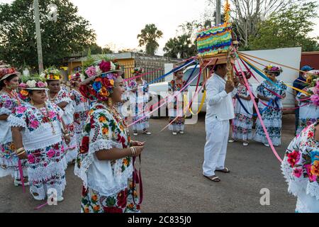 Le donne in hiipil ricamati e cappelli fioriti festive si preparano per la Danza della testa del maiale e del tacchino, o Baile de la cabeza del Foto Stock