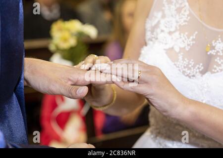 Il primo piano della sposa indossa un anello sul dito dello sposo Foto Stock