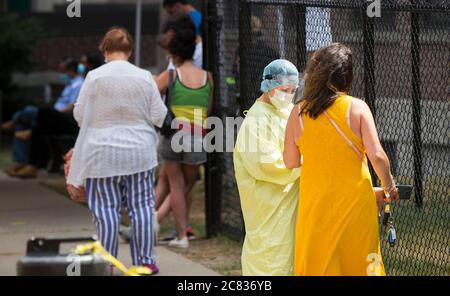 Toronto, Canada. 20 luglio 2020. Un operatore medico che indossa indumenti protettivi aiuta una donna a registrarsi al centro di valutazione COVID-19 di un ospedale di Toronto, Canada, 20 luglio 2020. Secondo il governo canadese, il numero totale di casi di COVID-19 in Canada era di 111,124 a partire da lunedì. Credit: Zou Zheng/Xinhua/Alamy Live News Foto Stock