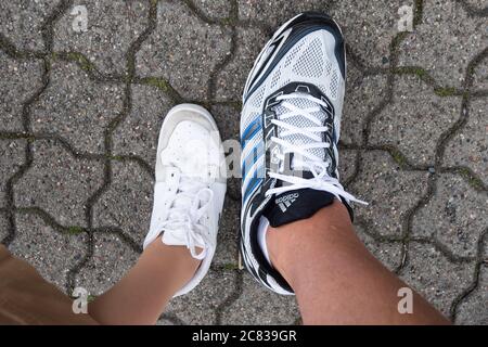 Hannover, Germania. 20 luglio 2020. Una donna con scarpe di taglia 38 si trova accanto a Jannik Könecke con scarpe di taglia 55. Jannik Könecke è alta 2.24 metri e uno dei tedeschi più alti. Credit: Julian Stratenschulte/dpa/Alamy Live News Foto Stock
