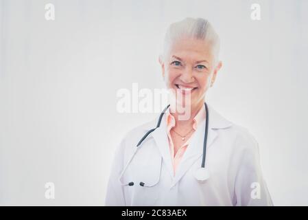 Ritratto di dottore anziano in piedi su sfondo bianco. Foto Stock