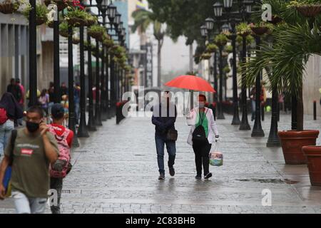 Caracas, Venezuela. 20 luglio 2020. Le persone che indossano maschere facciali camminano sotto la pioggia intorno a Plaza Bolívar nel centro di Caracas dopo che il governo nazionale ha radicalizzato la quarantena come misura preventiva contro la diffusione del coronavirus COVID-19 a Caracas il 20 luglio 2020. (Foto di Bernardo Suarez/INA Photo Agency/Sipa USA) Credit: Sipa USA/Alamy Live News Foto Stock