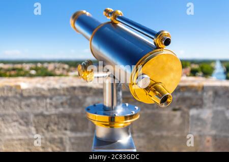 Primo piano di un cannocchiale in acciaio lucido e brillante sulle mura medievali della città francese di Aigues Mortes, che si affaccia sulla campagna sottostante Foto Stock