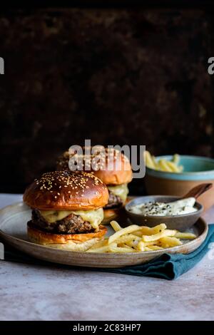 Cheeseburger con jalapeno mayo affumicato e patatine fritte Foto Stock