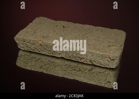 dolce halva isolato su sfondo rosso su tovagliolo di burlap Foto Stock