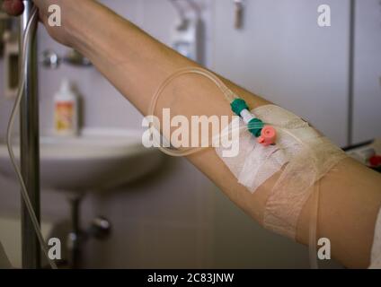 Primo piano della mano del paziente con l'ago per infusione in ospedale Foto Stock