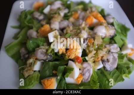 Ostrica piccante senza cotti con erbe tailandesi . Menu' di pesce servito al ristorante Thai. Foto Stock