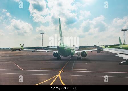 Vista dall'aereo all'ala e altri aerei in piedi sul grembiule dell'aeroporto Foto Stock