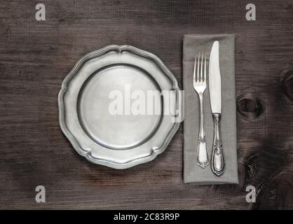 Posate in argento antico e teglia vintage su vecchio sfondo di legno Foto Stock