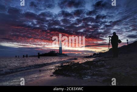 Un fotografo si allinea al suo scatto all'alba al faro di St Mary a Whitley Bay nelle prime ore del martedì mattina. Data immagine: Martedì 21 luglio 2020. Il credito fotografico dovrebbe essere: Owen Humphreys/PA Wire Foto Stock