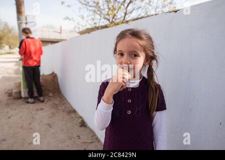 Trebujeni / Moldavia - 15 maggio 2020: Adorabile bambina moldava mangia gelato mentre si guarda la macchina fotografica Foto Stock