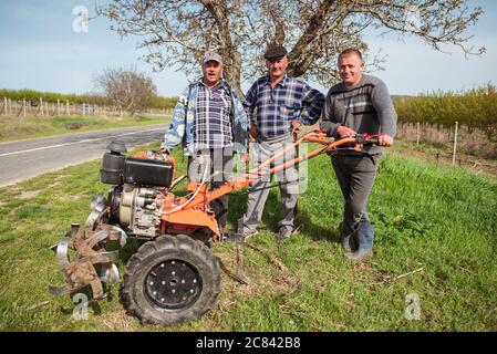 Trebujeni / Moldavia - 15 maggio 2020: Ritratto di agricoltori moldavi in campo accanto alla macchina aratrice vicino a terreni agricoli Foto Stock