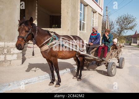 Trebujeni / Moldavia - 15 maggio 2020: Carrello di legno trainato da cavallo che porta una famiglia in villaggio Foto Stock