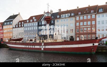 Copenaghen, Danimarca - 9 dicembre 2017: Vista sulla strada di Nyhavn o del Porto nuovo con il velivolo luminoso ormeggiato n. XVII Gedser Rev. Persone ordinarie camminano per la strada Foto Stock