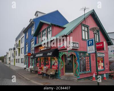 Islanda, Reykjavik, 30 luglio 2019: strada nel centro di Reykjavik con vecchia casa di metallo rosa storico con grill ristorante fast food Drekinn. Presto Foto Stock