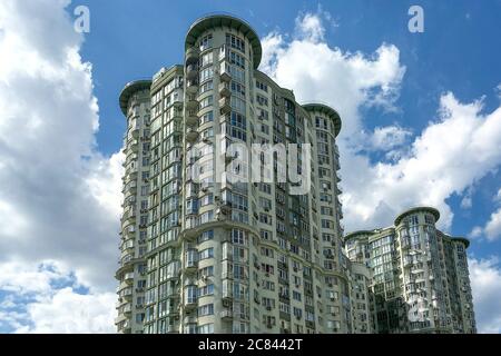 Un frammento di esterno, moderno ed alto edificio residenziale con molte finestre. Cielo blu e nuvole. Moderno quartiere cittadino di Kiev. Primo piano. All'aperto. Foto Stock