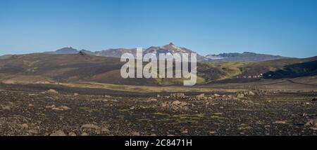 Paesaggio panoramico con rifugio di montagna botnar in Islanda sul sentiero escursionistico Laugavegur, valle verde in paesaggio vulcanico tra campi di lava. Presto Foto Stock