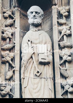 Immagine in primo piano verticale di una statua di un santo grigio sulla chiesa romana nella città di Estella in Navarra, Spagna Foto Stock