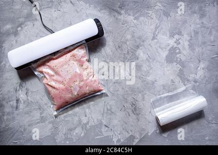 Confezionamento sottovuoto di carne per stoccaggio a lungo termine. Filetto di tacchino in un sacchetto sottovuoto. Disposizione piatta. Foto Stock