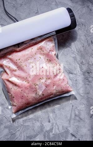 Confezionamento sottovuoto di carne per stoccaggio a lungo termine. Filetto di tacchino in un sacchetto sottovuoto. Disposizione piatta. Foto Stock