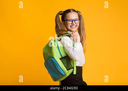 Studentessa in posa con lo zaino da scuola sorridendo alla fotocamera, Studio Shot Foto Stock