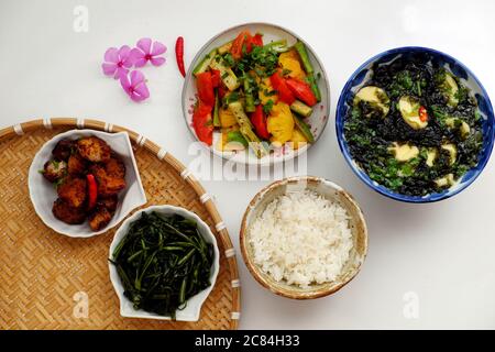 Cucina vietnamita vegana, pasto giornaliero per la famiglia a pranzo, cena, zuppa di alghe, tofu, verdure fritte, pane secco cuoco con salsa, spinaci in acqua bollita Foto Stock