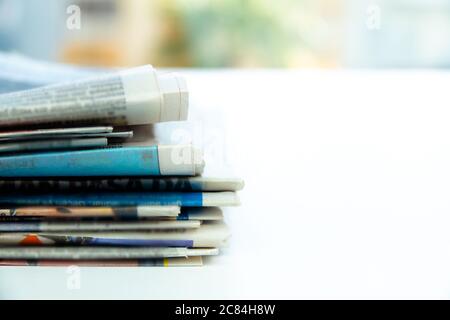 Mucchio di giornali freschi del mattino sul tavolo in ufficio. Perni di banco piegati e impilati Foto Stock